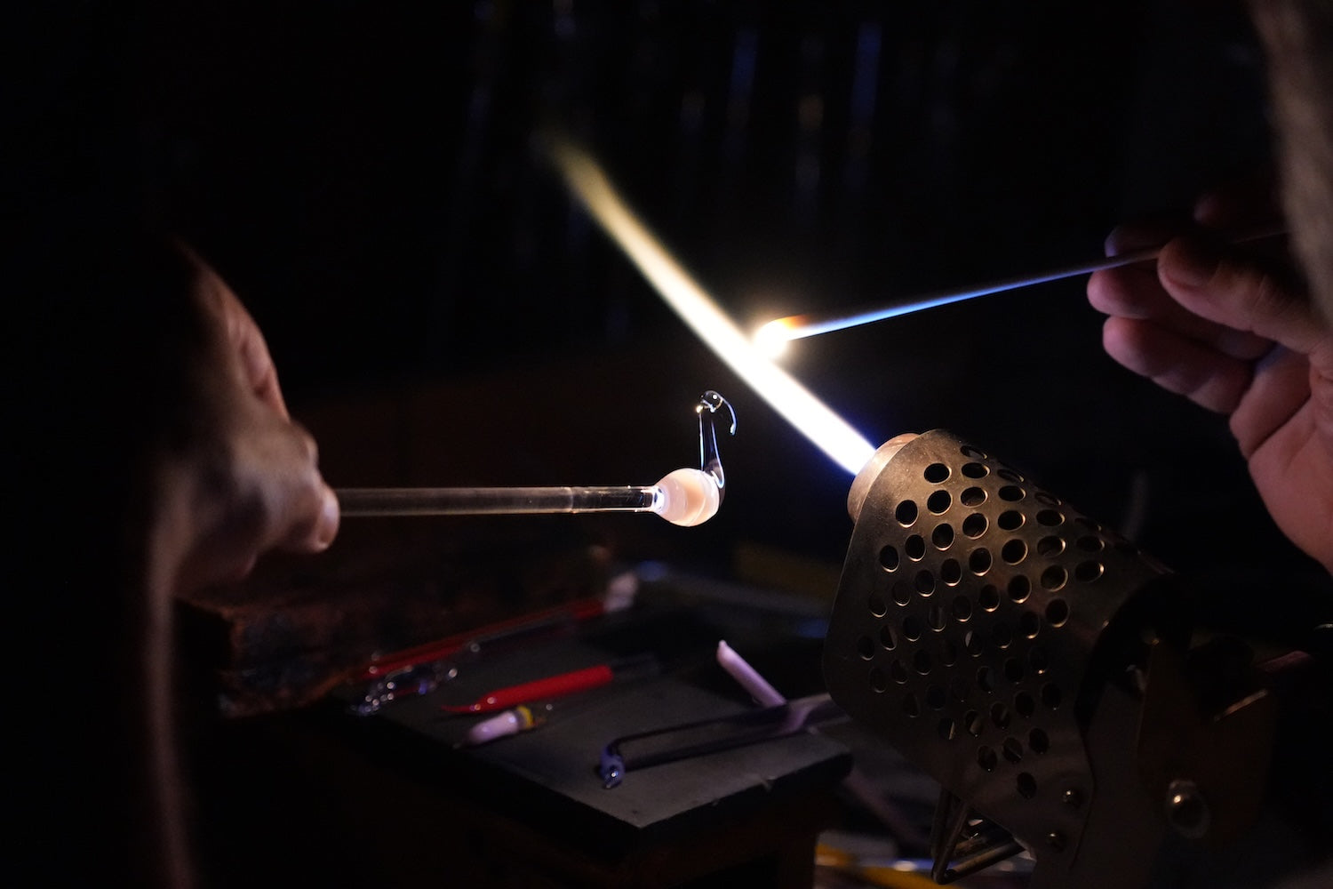 Glasblaeser stellt am BrennerFlamingo aus Glas her 