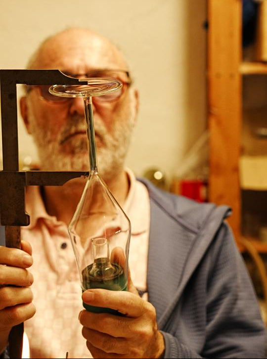 Glasbläser misst Länge des Stiels eines Champagnerglases